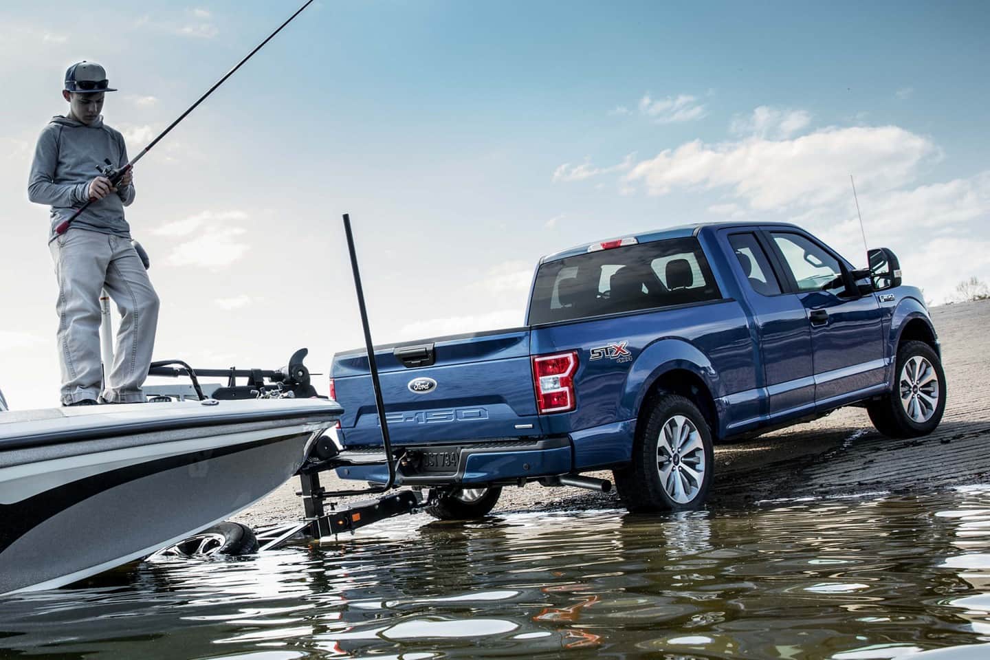 Image of a blue Ford F-150 truck pulling a boat out of the water.