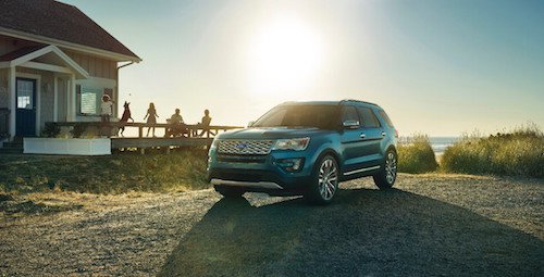 Image of a blue Ford Explorer parked by the beach.