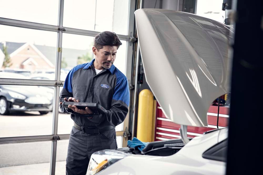 Technician fixing car Ford service center